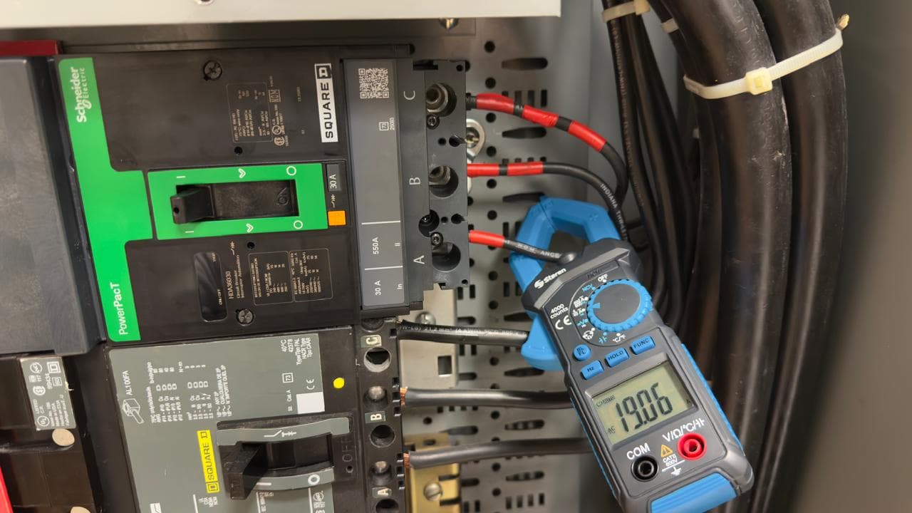 INCOELEMEC realizando mantenimiento eléctrico y medición de parámetros con amperímetro de gancho en tablero.